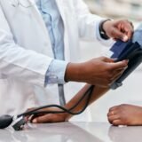 Doctor primario tomando presion arterial para evaluacion de salud cardiaca
